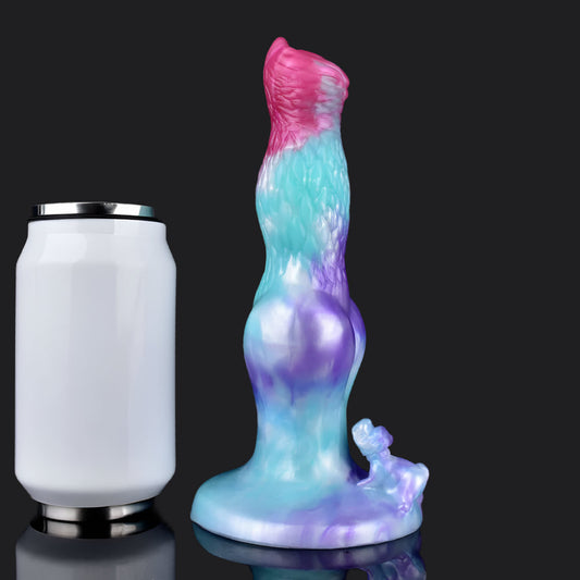 Colorful dragon dildo next to a syringe on a reflective surface, highlighting unique design and features.